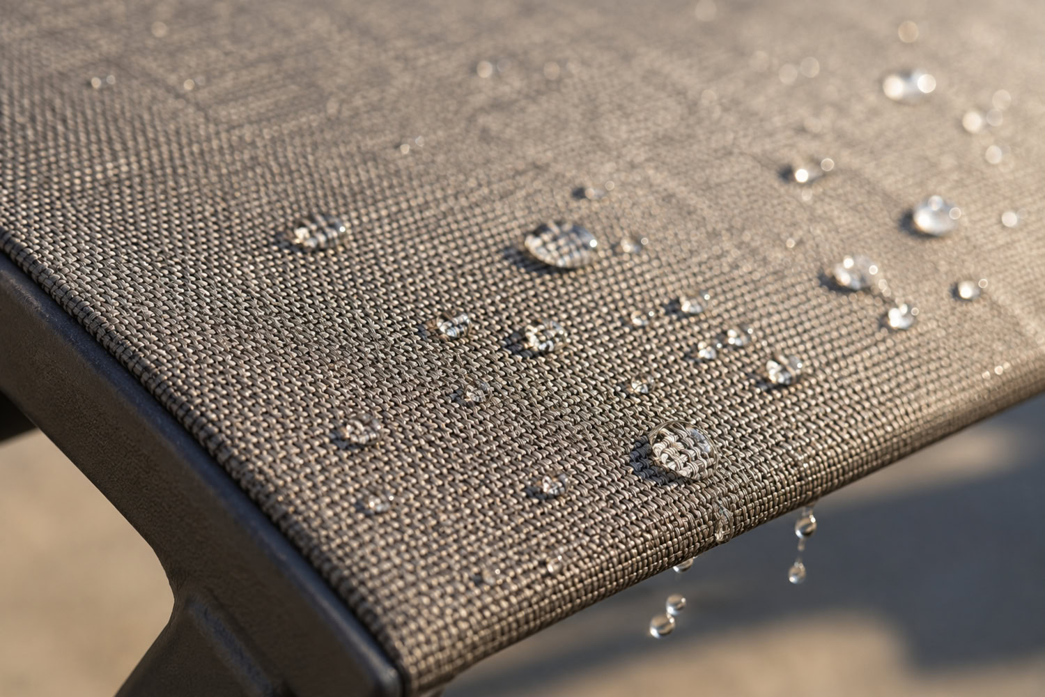 Taut mesh sling seat with water beading off the woven surface